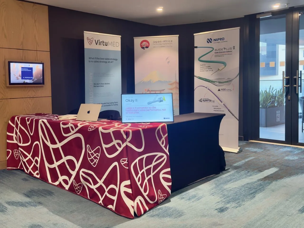 The finished ruby tablecloth on a congress stand, beside Virtumed and supplier pull-up banners