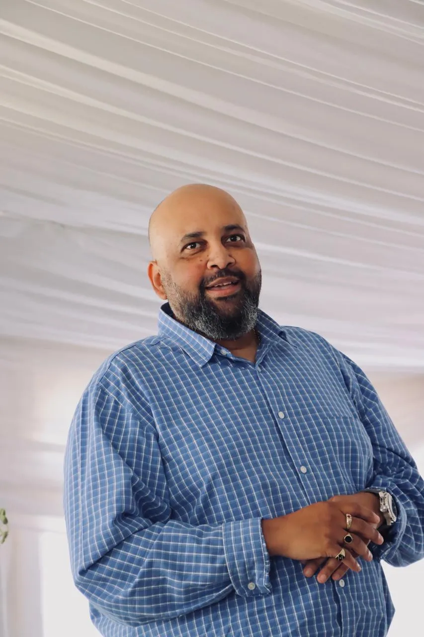 A man in a checked shirt standing in a marquee