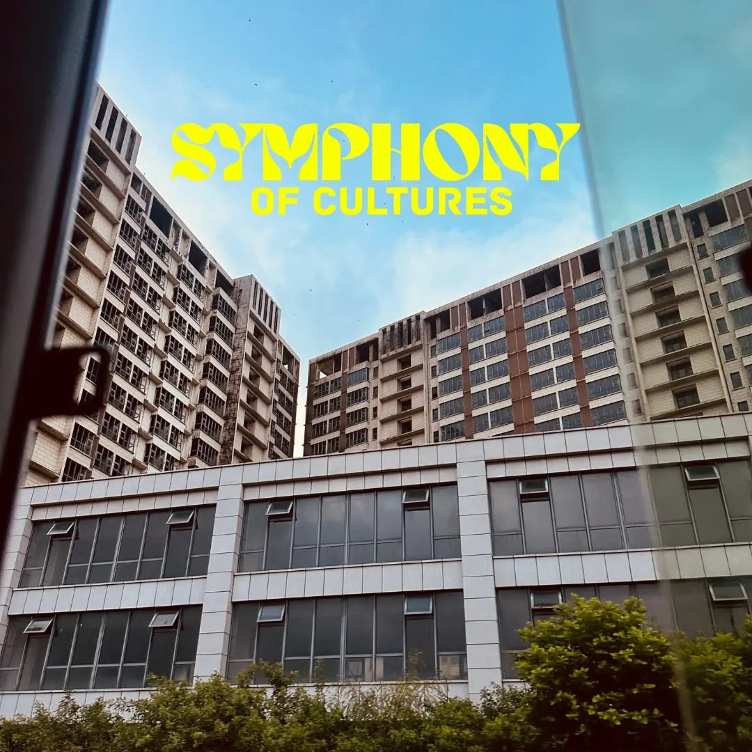 Apartment blocks against a blue sky, titled Symphony of cultures