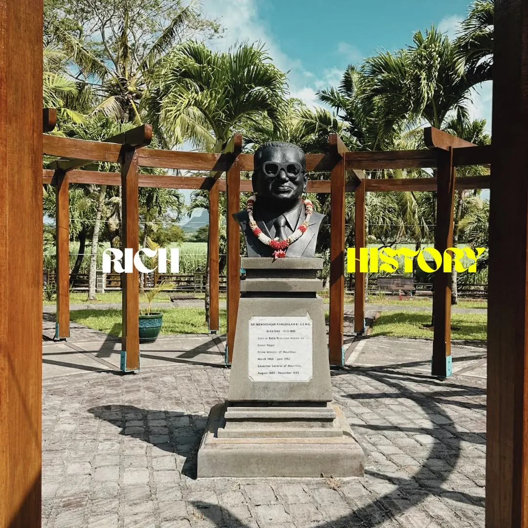 A bronze bust in a garden pergola, titled Rich history
