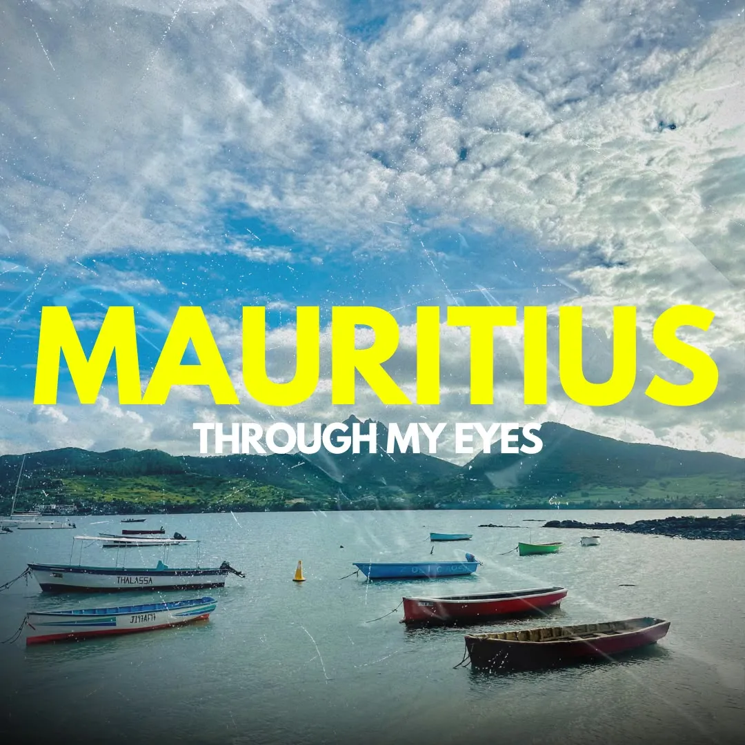Boats moored in a bay under mountains, titled Mauritius, through my eyes