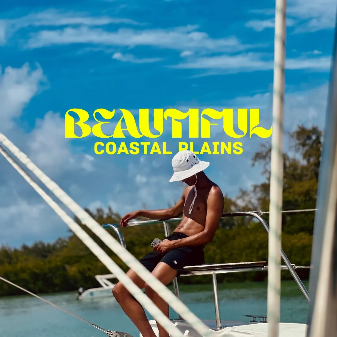 A man sitting on the rail of a boat, titled Beautiful coastal plains
